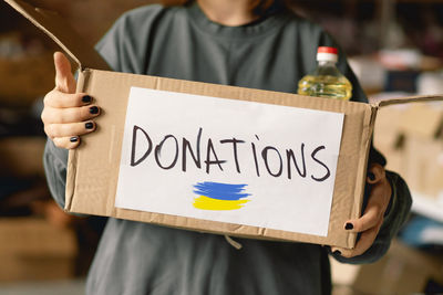 Volunteer teengirl preparing donation boxes for people in need in ukraine.