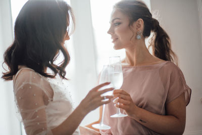 Side view of a young woman drinking glass