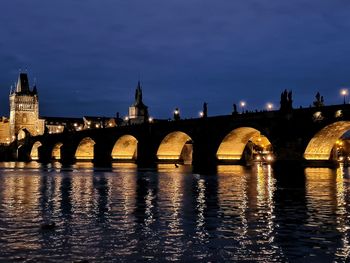 Arch bridge over river at night