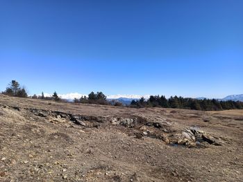 Scenic view of desert against clear blue sky