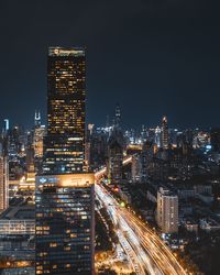 Illuminated buildings in city against sky at night