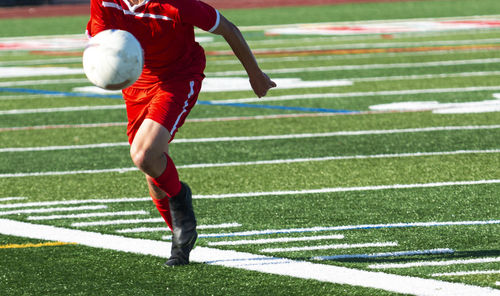 Full length of woman playing soccer on field