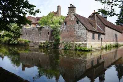 Old building by lake against sky