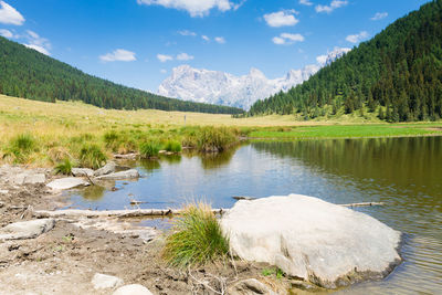 Scenic view of lake by mountains against sky