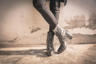 Low section of woman standing against wall