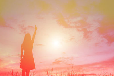 Low angle view of silhouette woman standing against sky during sunset