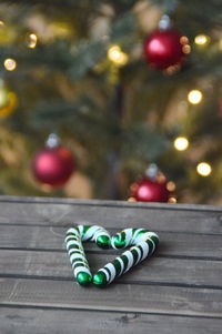 Close-up of candy canes on table by christmas tree