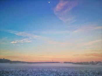 Scenic view of snow covered landscape against sky during sunset