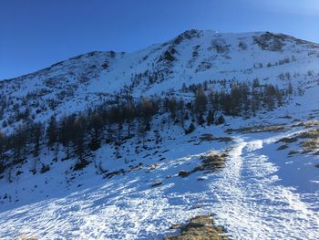 Scenic view of snow mountains against clear blue sky