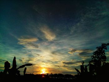 Low angle view of silhouette sculpture against sky at sunset