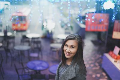 Portrait of smiling woman standing outdoors at night