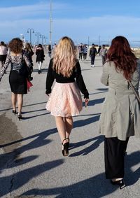Rear view of women walking on road