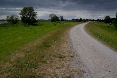 Road amidst field against sky