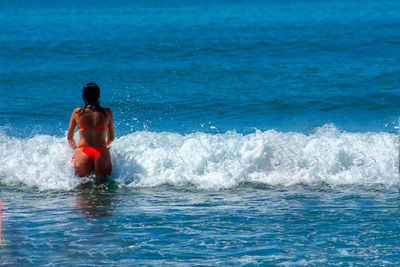 Rear view of shirtless man in sea