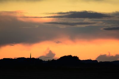 Scenic view of silhouette field against romantic sky at sunset