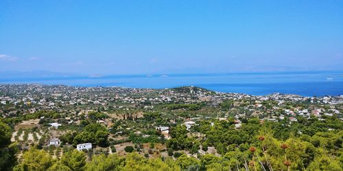 Scenic view of sea by buildings against blue sky