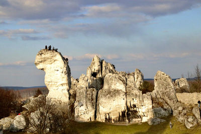 Rock formations on landscape against cloudy sky