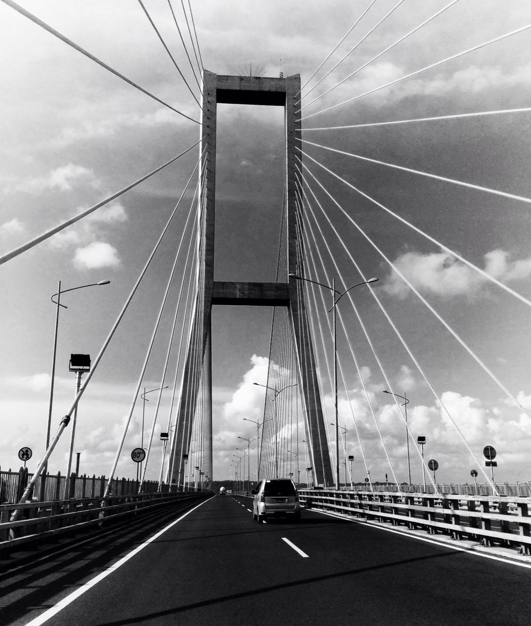 transportation, sky, the way forward, connection, road, road marking, diminishing perspective, mode of transport, car, on the move, cloud - sky, vanishing point, highway, cable, travel, bridge - man made structure, built structure, land vehicle, architecture, cloud