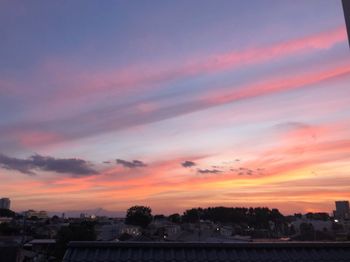 View of townscape against dramatic sky during sunset