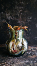 Close-up of fishes in jar on table