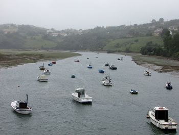 High angle view of sailboats moored on river against sky