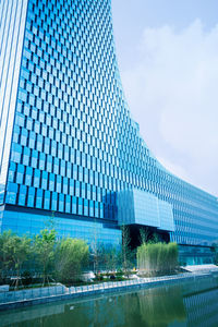 Low angle view of modern building against cloudy sky