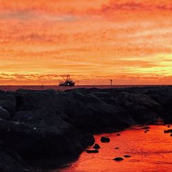 Scenic view of sea against orange sky