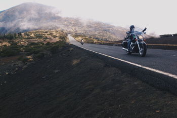 PERSON RIDING MOTORCYCLE ON ROAD