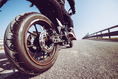 Low section of man riding bicycle on road