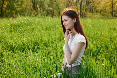 Young woman sitting on grassy field