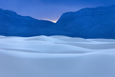 Scenic view of snowcapped mountains against blue sky