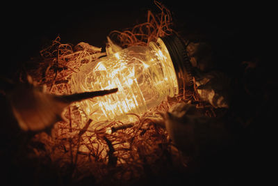 Close-up of illuminated lights in jar and strings
