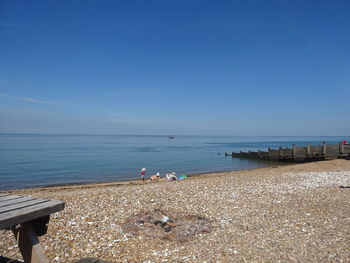 Scenic view of beach against clear blue sky