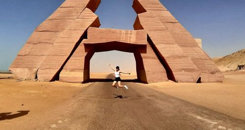 Full length rear view of woman walking in desert