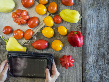 Reflection of man on digital tablet by fresh vegetables on table