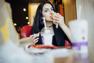 Woman eating a hamburger in a cafe