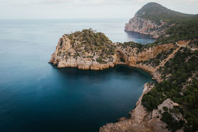 Rock formations by sea against sky