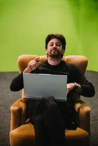 Man using laptop while sitting on sofa at home