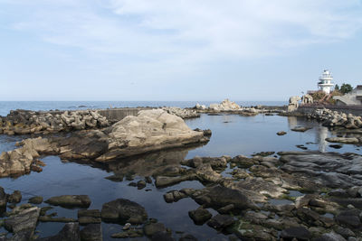 Rocks by sea against sky