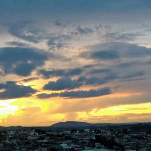 Scenic view of sea and buildings against sky during sunset