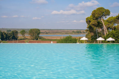 Scenic view of swimming pool by sea against sky