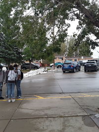 Vehicles on road against trees in city