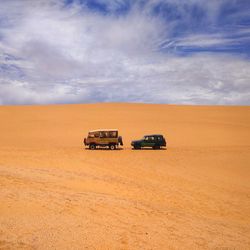 View of car on desert against sky