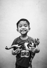 Happy boy standing against wall