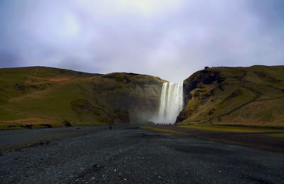 Scenic view of waterfall against sky