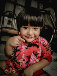 Portrait of smiling girl sitting at home