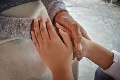 Midsection of couple holding hands