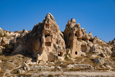 Low angle view of rock formations against clear blue sky