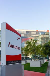 Information sign by building against clear sky