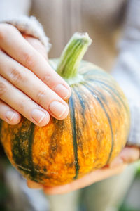 Midsection of woman holding pumpkin